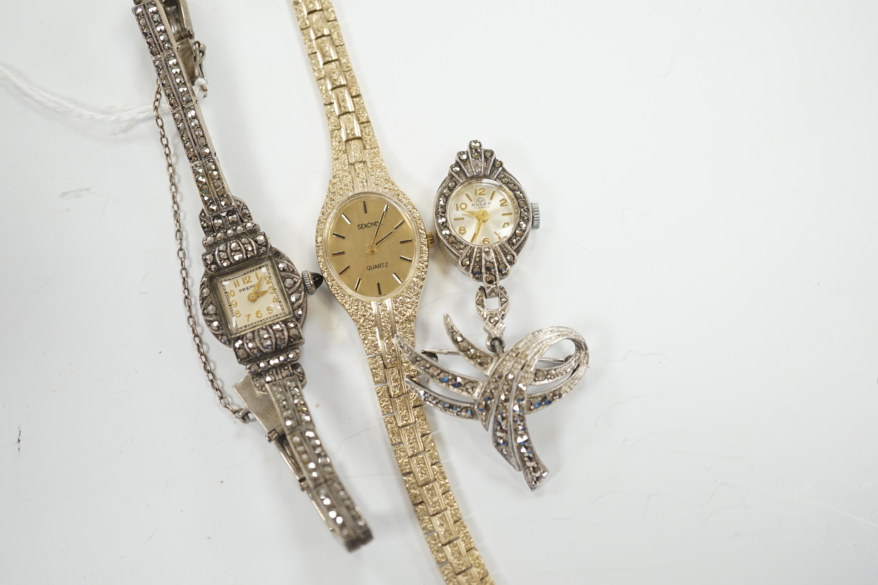 A late 1950's silver and marcasite set Premex manual wind cocktail watch, a similar lapel watch and a lady's Sekonda quartz watch.